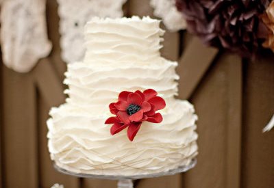 Велика червона квітка на білому торті